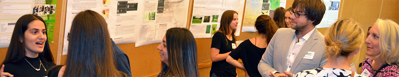 eleven people in conversation in front of several scientific posters at a DNA barcoding symposium